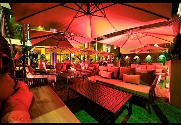 Terrasse extérieure du Yard sous parasols rouges